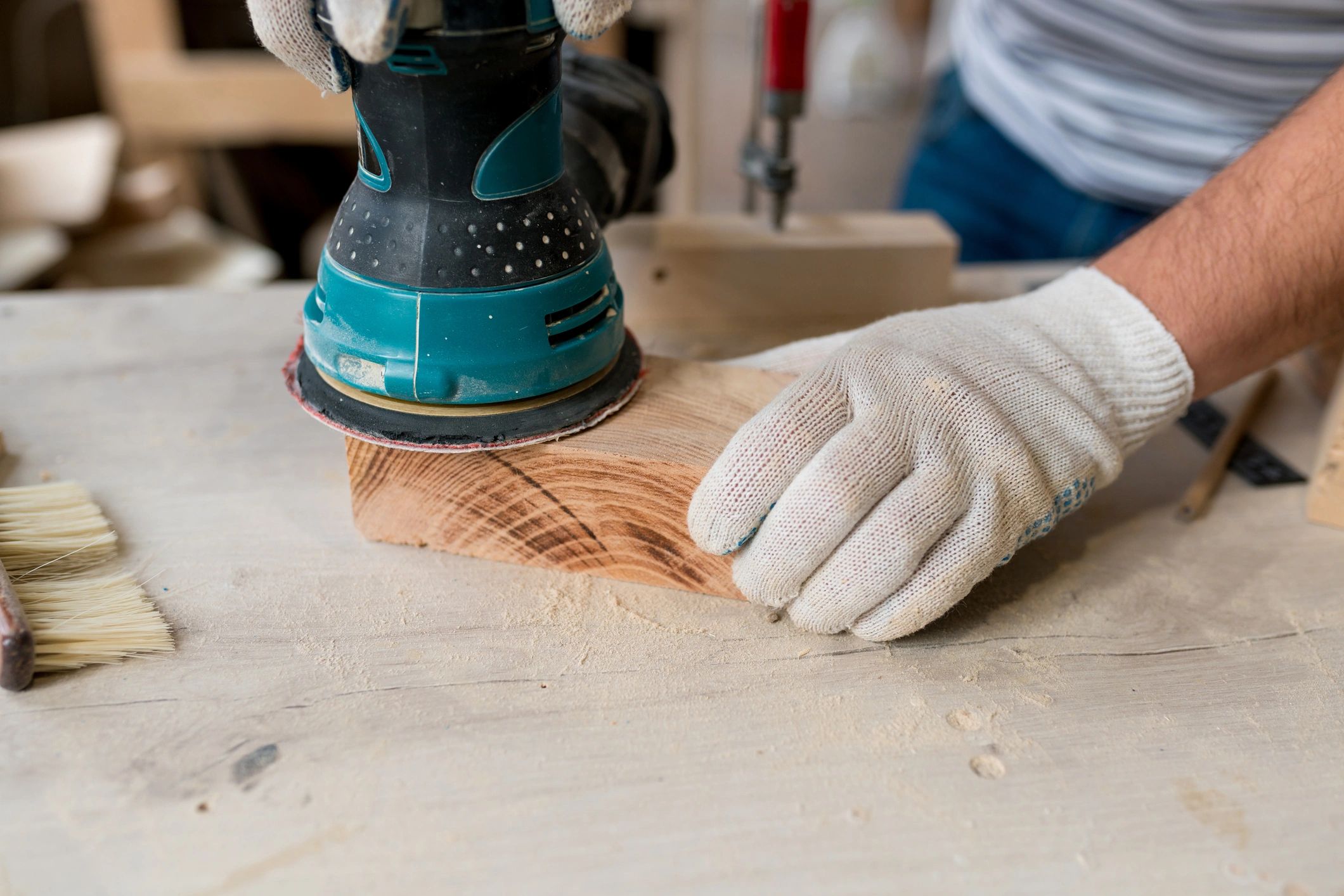Woodworker sanding hardwood in a workshop