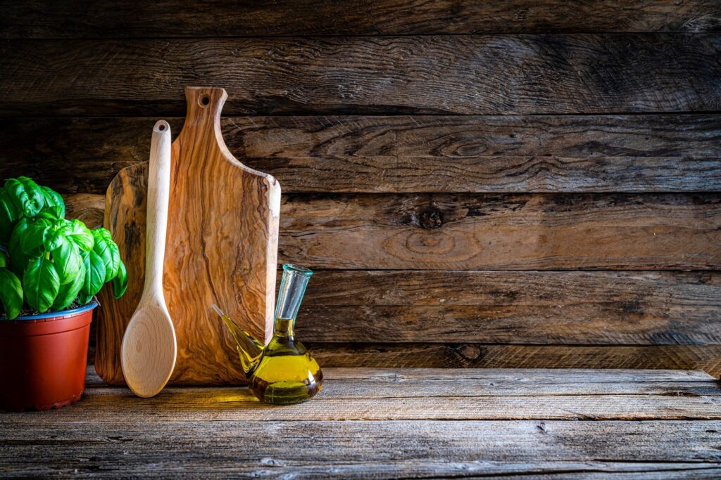 Cooking backgrounds: cutting board and kitchen utensils on wooden table. Copy space
