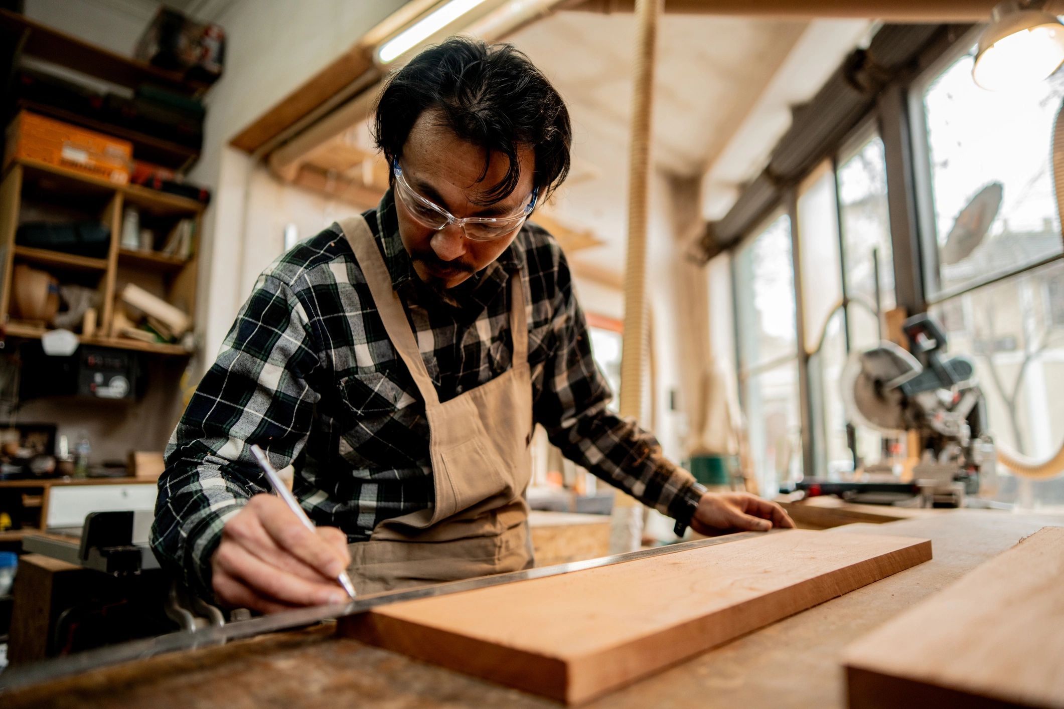 Craftsman measuring wood in a workshop
