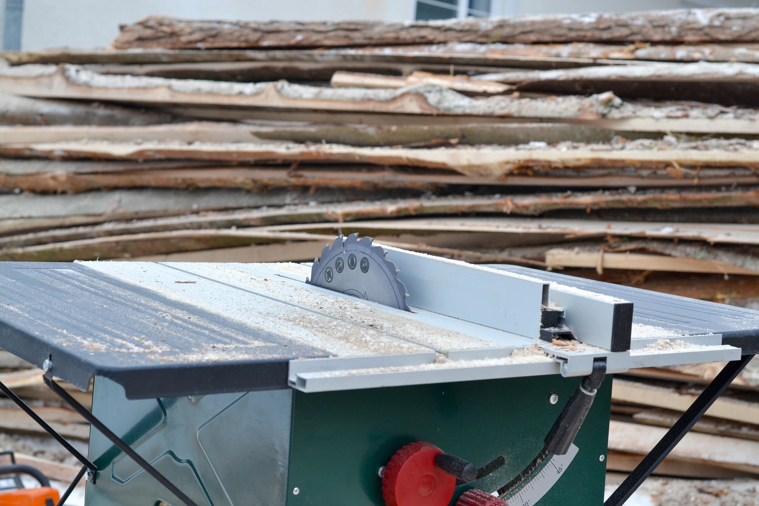 Table saw with stacked timber in the background